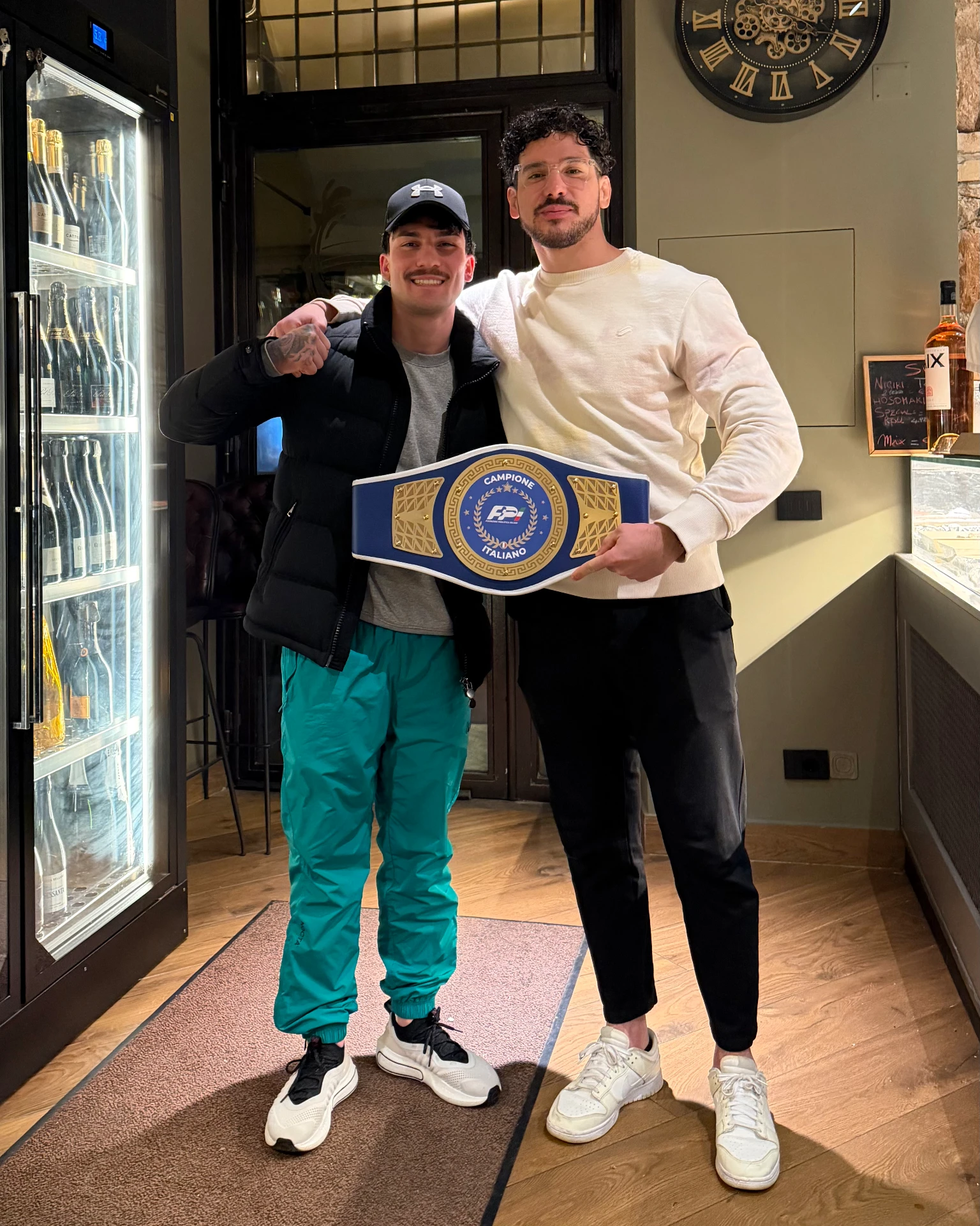 Federico Angotti con un atleta e la cintura di campione italiano
